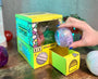Sugoi Mart mini yellow colored gachapon box with purple capsule toy. thumbnail 1